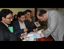 استاد شكوهي در حال مزين كردن كتاب هواداران به امضاي خويش